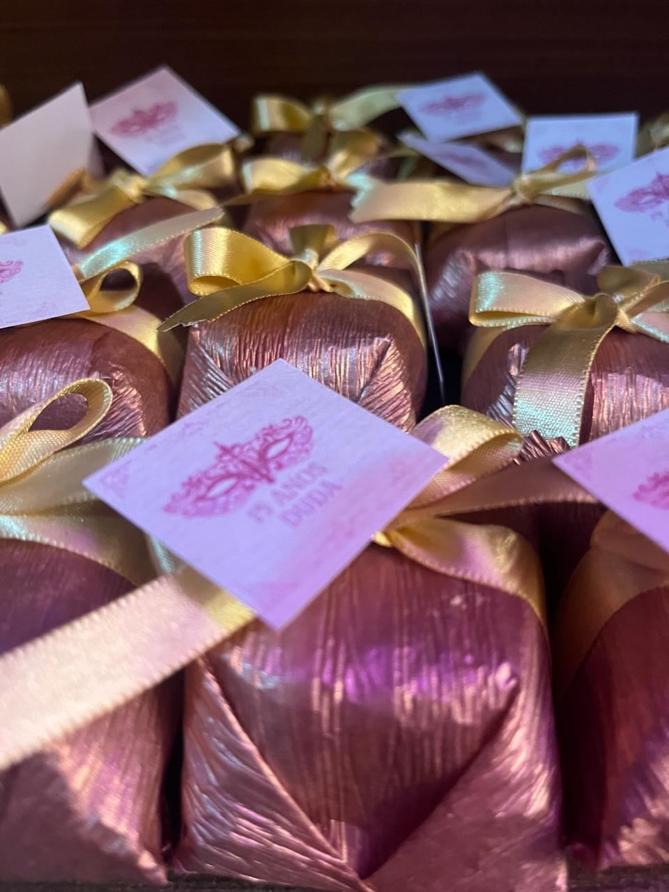 Bem casados em papel bronze metálico com laço dourado e tag personalizada de festa de 15 anos