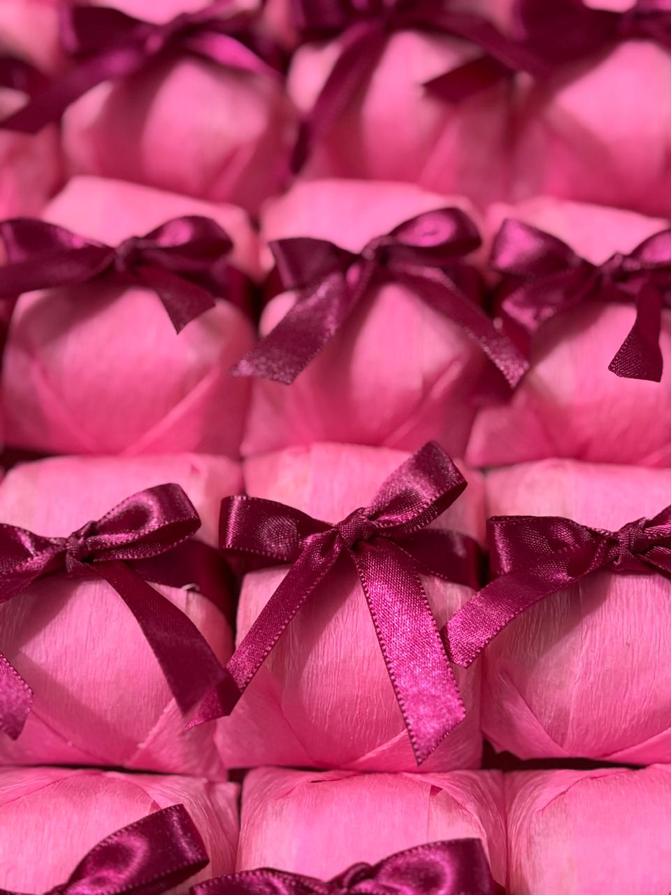 Bem casados embalados em papel rosa com laço de cetim bordô