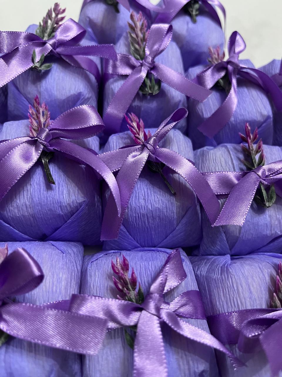 Bem casados embalados em papel lilás com laço de cetim lilás e raminho de lavanda