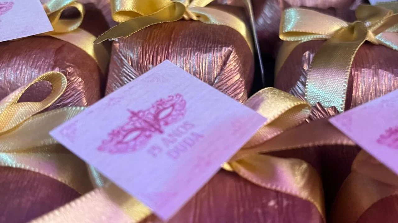 Bem vividos embalados em papel bronze metálico com laço dourado e tag de festa de 15 anos