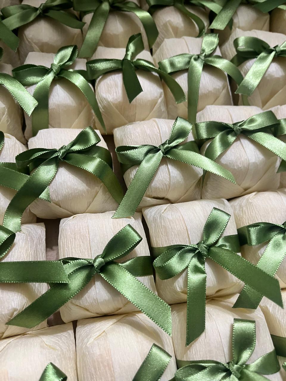 Bem casados embalados em papel creme com fita e laço de cetim verde-oliva