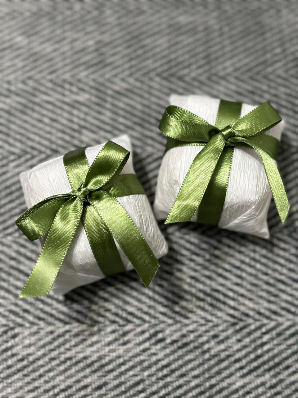 Dois bem casados embalados em papel branco, com laço de cetim verde-oliva