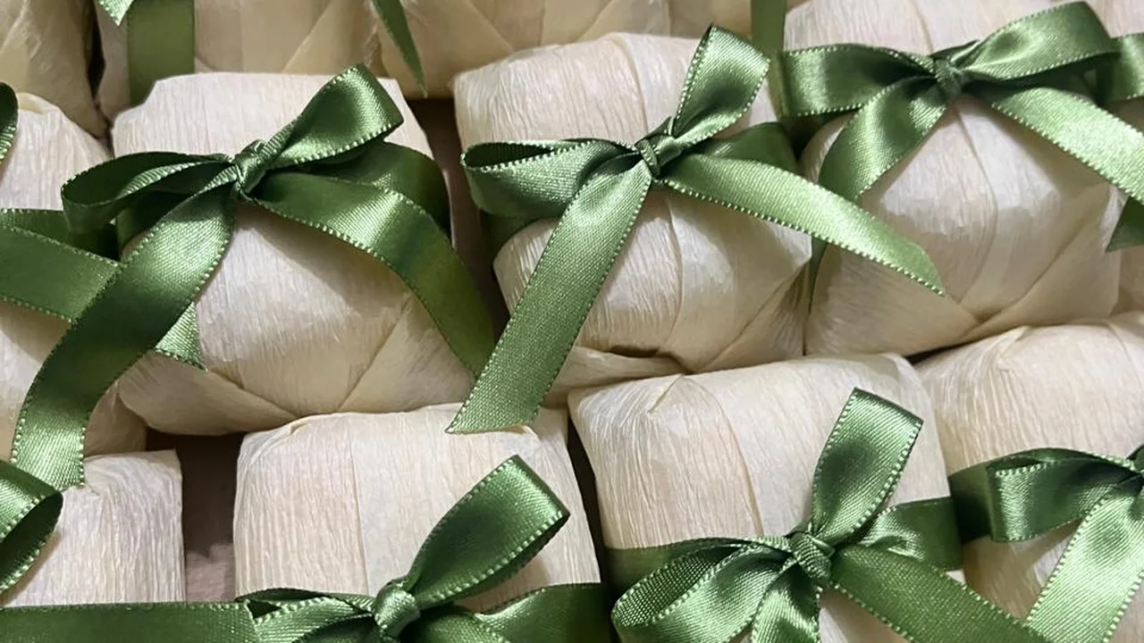 Bem casados embalados em papel creme com fita e laço de cetim verde-oliva